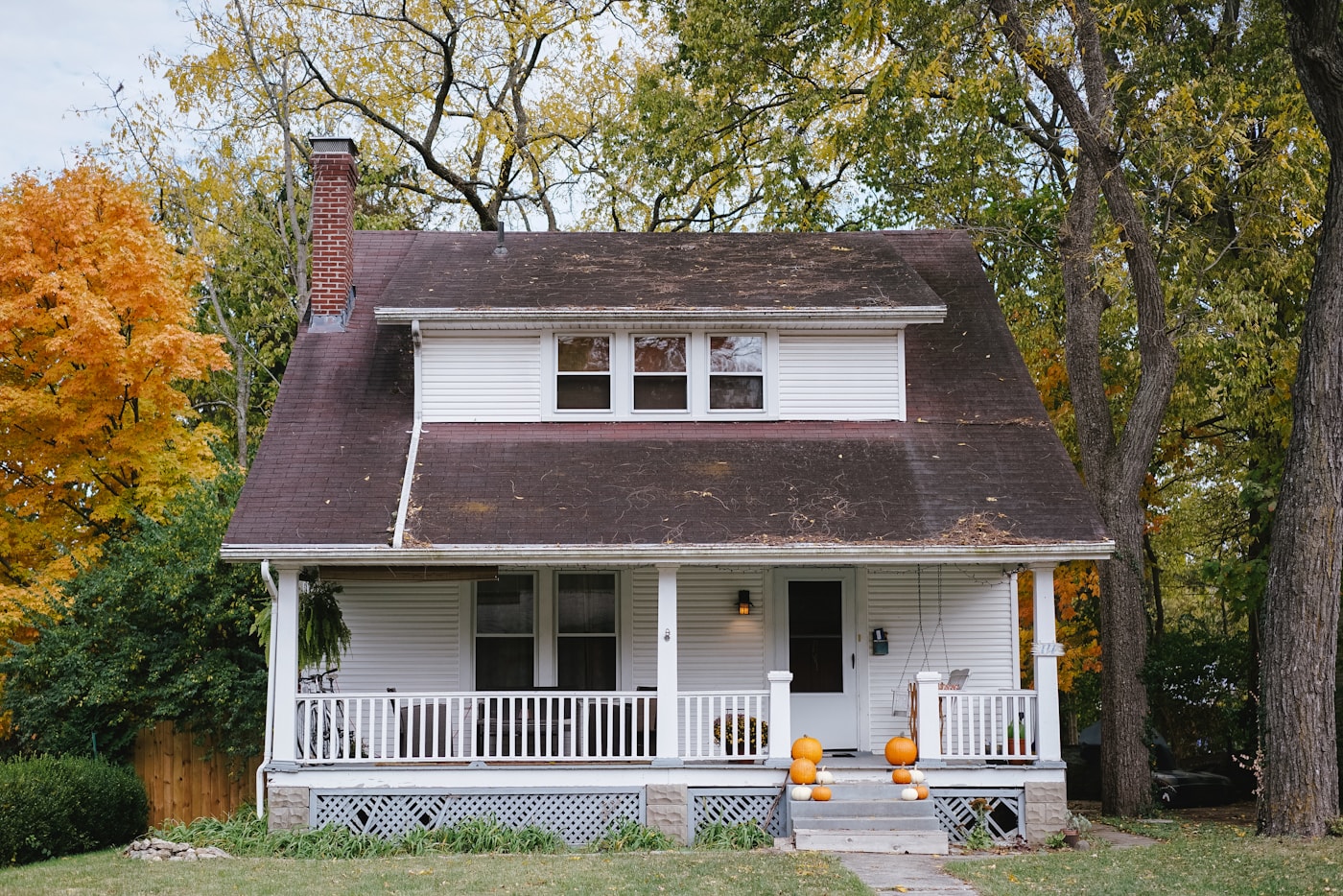 Painted Vancouver craftsman cottage with white clapboard siding and autumn trees